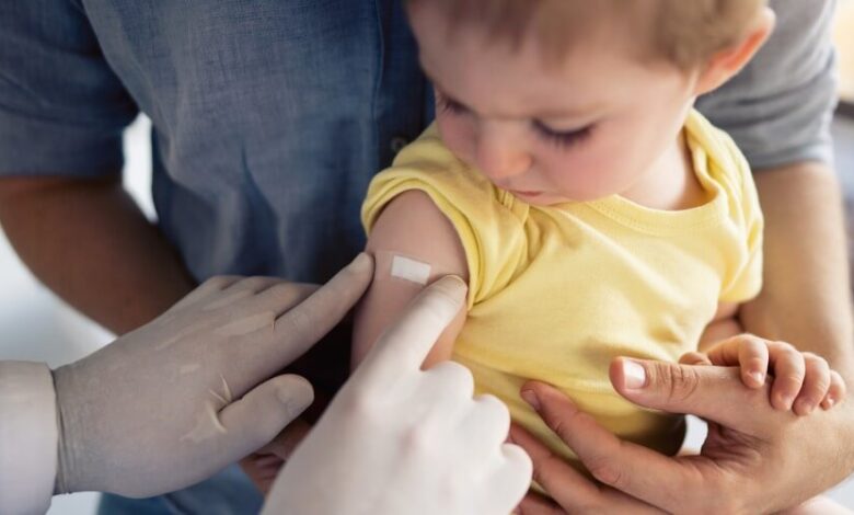 doctor poniendo vacuna de COVID-19 a menor