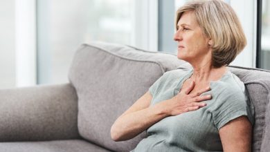 Mujer tocando su pecho en el lado del corazón por molestia